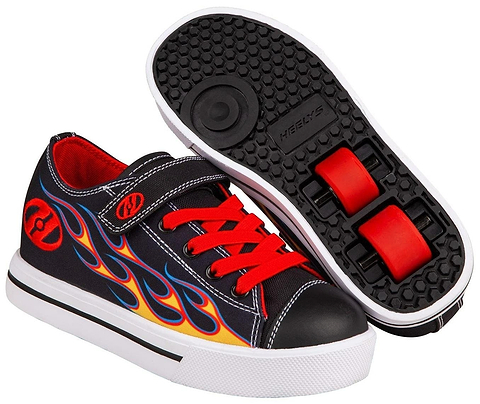 A pair of Heelys Snazzy X2 Boys Shoes by Heelys in black with yellow and red flame details, featuring canvas uppers, red laces, velcro strap, and two retractable wheels with ABEC 3 bearings shown on the sole.