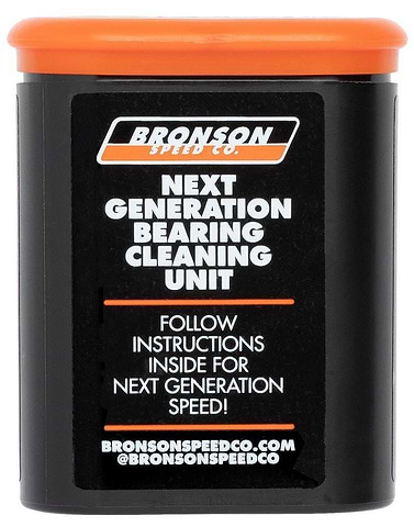 A black cylindrical container with an orange lid from Bronson features a label reading "Bronson Speed Co. Bearing Cleaning Unit," ideal for cleaning bearings. Instructions for speed enhancement are included, along with the website and social media handle at the bottom.