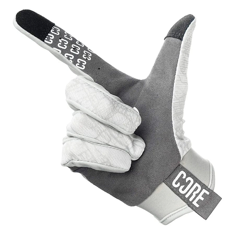 Introducing the CORE Aero Skate Protection Gloves - Kieran Reilly Signature White, these gloves enhance grip functionality with their gray and white design complemented by a black index fingertip. The glove is styled in a manner that mimics a finger gun gesture, further distinguished by the word "CORE" prominently displayed on the wristband.