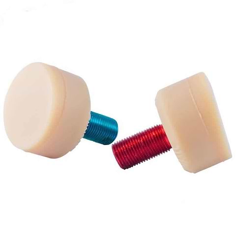 Two Gumball V2 Natural Toe Stoppers from Gumball, designed with round beige caps and threaded plastic screws, are displayed. Resembling gumball toe stops, one screw is blue and the other is red. They face opposite directions with the beige caps on top, showcasing ultimate stopping power made from a proprietary rubber blend.