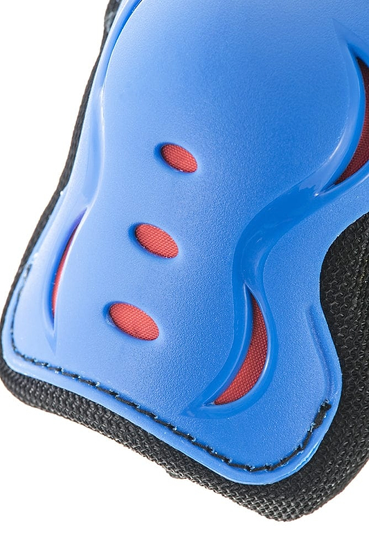 Close-up image of a blue protective pad from the SFR Essentials Junior Triple Skate Protection Pad Set - Blue / Red by SFR, showcasing three small ventilation holes that reveal a red layer beneath. The pad features black textured edges and curved contours, expertly designed for protective gear.