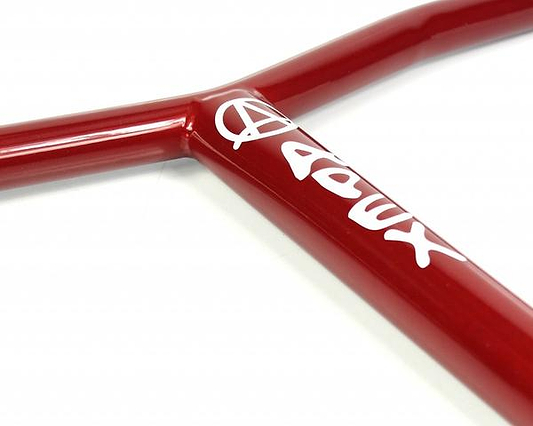 Close-up of an Apex Bol Steel Standard SCS Stunt Scooter Bar in red, made from durable Chromoly Steel, featuring a white Apex logo with stylized letters. The focus is on the intersection of the bars, emphasizing the glossy and scratch-resistant finish along with the logo's design.
