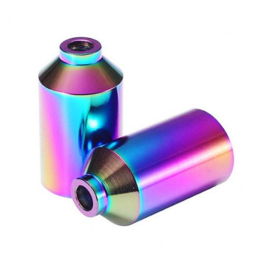 Two Blunt Envy Aluminium Stunt Scooter Pegs in the Oil Slick Neochrome finish show off a shiny, iridescent surface that displays a spectrum of colors including blue, pink, and green. One peg is standing upright while the other lies horizontally.