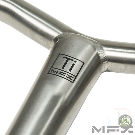 Close-up of a metal T-joint with a smooth weld, featuring the logo "Ti MFX" printed on the surface. Crafted from Grade 9 Titanium, this piece showcases exceptional craftsmanship and robust design, similar to the Madd Gear MGP MFX BAMF Titanium Oversized SCS Stunt Scooter Bar - Raw 660mm x 660mm. The plain background accentuates its shiny, metallic texture.