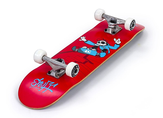 The Enuff Skully Red Mini Complete Skateboard, measuring 7.25" x 29.5", is an entry-level board featuring a vibrant design with a cartoon character sporting a hat and sunglasses as they jump above stylized buildings. The word "Spray" is boldly displayed in white on the skateboard's tail, highlighting its striking style.