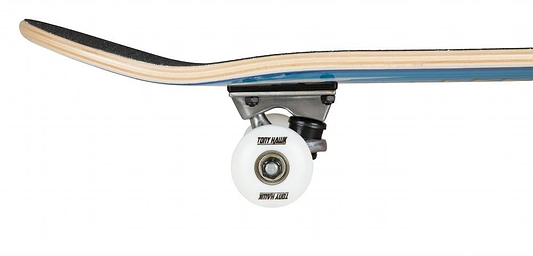 A close-up of the Tony Hawk 180 Series Wingspan Complete Skateboard's wheel and truck highlights the underside and part of the deck. The white wheel features text, and the board displays a blue and woodgrain finish with black grip tape on top, perfect for those seeking an entry-level experience.