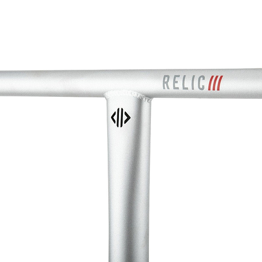 Close-up of the Drone Relic 3 Steel Oversized SCS Stunt Scooter Bars in a raw finish, featuring a silver T Bar handlebar crafted from durable Chromoly 4130 steel. The brand name "RELIC" is prominently displayed in red and gray letters, while a small Drone logo sits below the joint on the metallic surface, accented by visible weld marks.