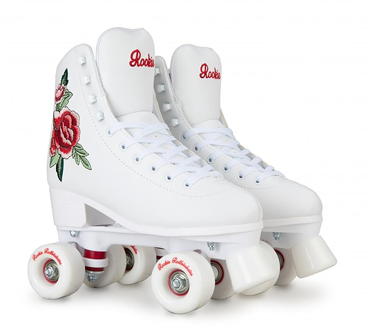 The Rookie Rosa Quad Roller Skates - White, from the brand Rookie, are crafted using vegan-friendly materials. These stylish white roller skates are adorned with elegant red embroidered designs on the sides. They feature durable white wheels and have "Rookie" proudly inscribed on the tongue, combining both style and ethical design.