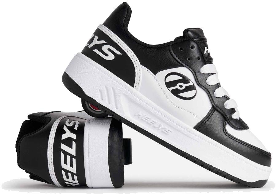 The Heelys Rezerve Low Boys Shoes in Black/White feature one shoe upright and another tilted to showcase the wheel with ABEC 5 bearings—ideal for kids starting out with skating.