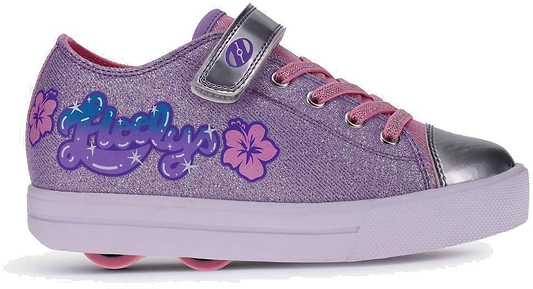 The Heelys Snazzy X2 Girls Shoes by Heelys feature a lavender, pink, and silver design with pink laces, a shiny silver toe cap, hibiscus flower details, two wheels, and glittery blue and purple Heelys logos on the side.