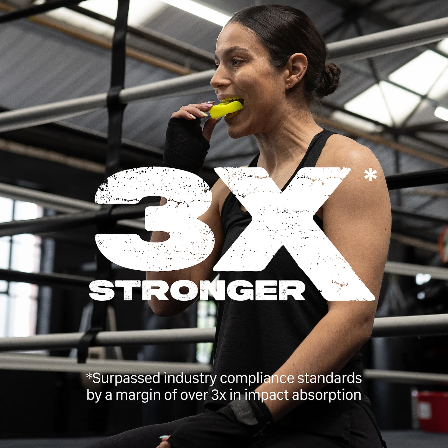A woman in athletic wear sits in a boxing gym, fitting the Safejawz Intro Series Protection Mouthguard - Fluro Yellow. Large text reads “3X STRONGER,” with a note: “Surpassed industry compliance standards by over 3x in impact absorption.”.