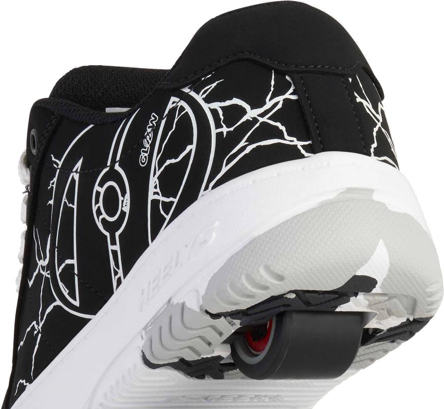 Close-up of the Heelys Kolect Glow Boys Shoes in black/white, featuring a single retractable heel wheel and white lightning-like patterns. These Heelys glow in the dark and are perfect for skating fun.