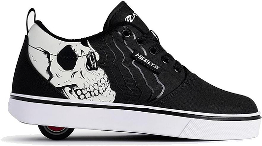 The Heelys Pro 20 PRNT Glow Boys Shoes in black/white feature a glow-in-the-dark skull graphic, white midsole, and low-profile wheels in the heel.