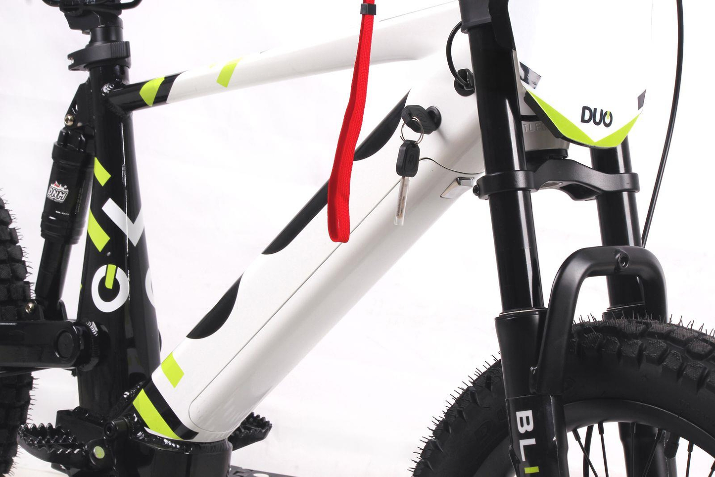 Close-up of the Duo 18" Blitz Kids Electric Balance Bike in white/black, highlighting the battery compartment with key and red strap, plus visible front suspension fork and part of the tires.