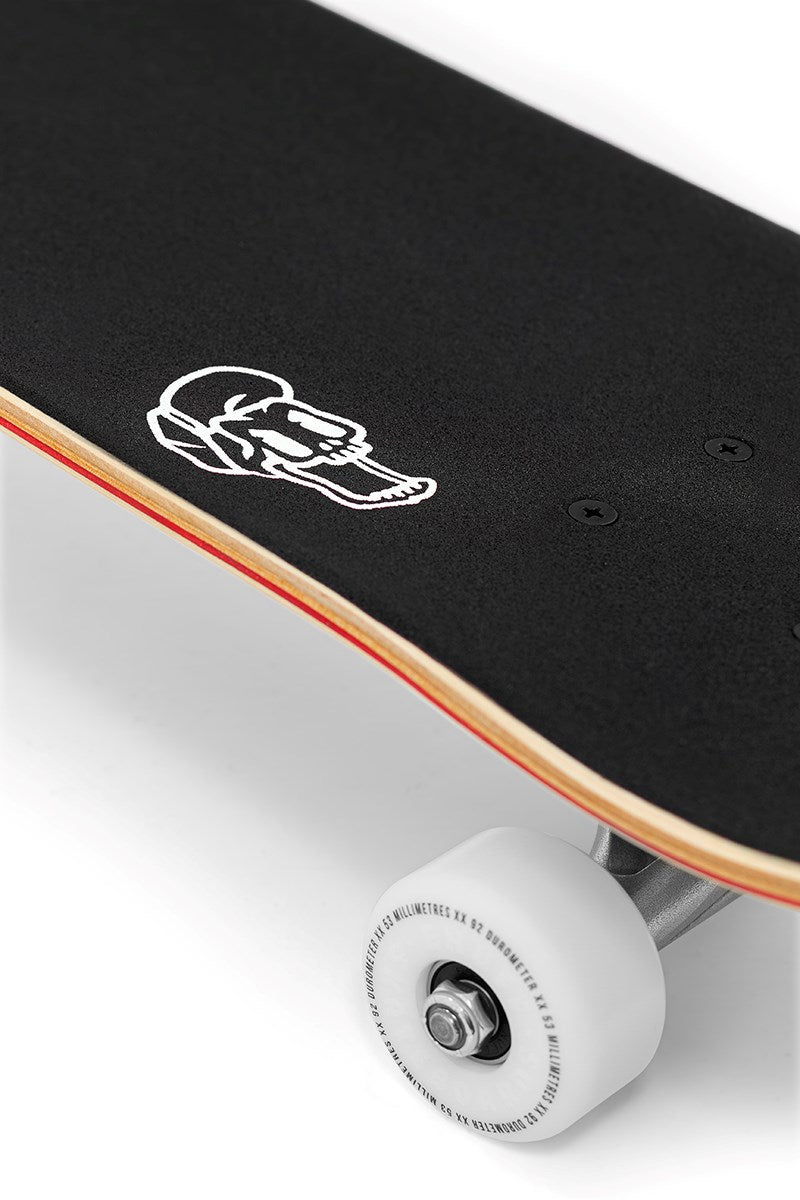 Close-up of the Enuff Lucky Cat Natural Complete Skateboard - 8.0" x 32" with black grip tape, a white cat graphic, white wheels, silver trucks, and visible wooden deck edge. Ideal beginner skateboard for street and park skating by Enuff.