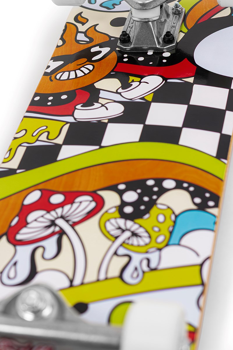 Close-up of the Enuff Meltworld Confused Complete Skateboard by Enuff (7.75" x 31.5") showing vibrant cartoon art with mushrooms, a checkered pattern, melting shapes, and a mischievous flame character. Wheels and trucks are partially visible on this full-size board.