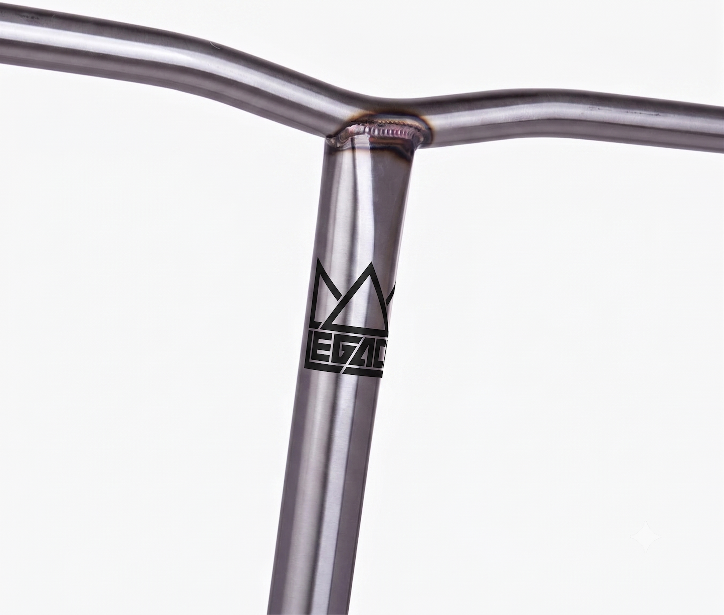 A close-up of the Legacy Chromo Lite Steel Oversized HIC/SCS Stunt Scooter Bars (Raw, 680mm x 610mm) shows a welded chromoly handlebar with a stylized crown and “LEGACY” logo on the vertical bar, set against a plain white background.