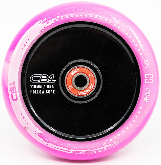 A close-up of the CORE CB1 110mm Nylon Stunt Scooter Wheel in white/pink, featuring a black hollow core and red bearing—perfect for beginners. Text on the wheel includes "CORE," "CB1," and "110mm / 88A Hollow Core.