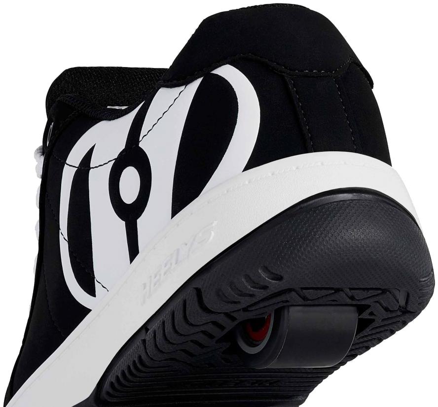 Close-up of the heel on Heelys Kolect Boys Shoes in black and white, featuring a retractable wheel with ABEC 5 bearings in the sole and circular tread. Bold graphic design highlights this signature style by Heelys, ideal for skating.