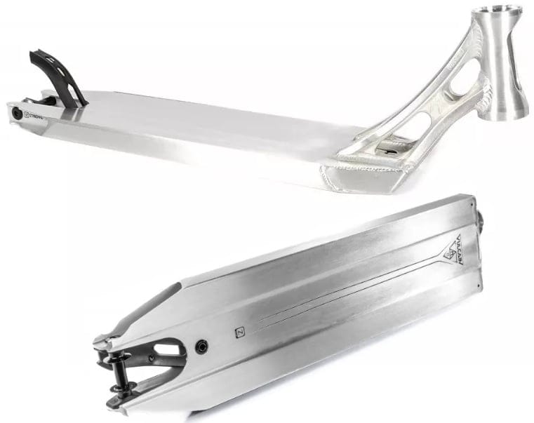 The Ethic DTC Vulcain V2 12 STD Raw Silver Stunt Scooter Deck from Ethic features a sleek silver finish with a minimalist aesthetic. It is designed with a flat top surface, open side cutouts to reduce weight, and a reinforced headtube. The deck offers versatile angles and includes the 12 STD bearing system, which can be observed from both side and top perspectives.