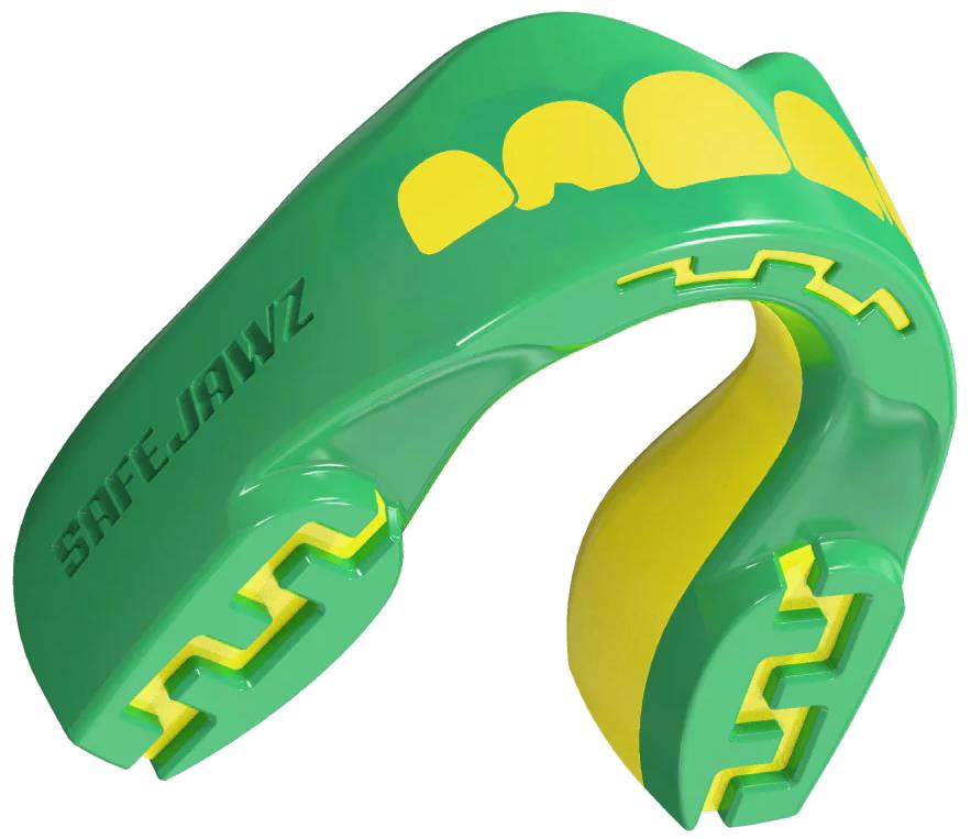 The Safejawz Extro Series Protection Mouthguard - Ogre is a green and yellow sports mouthguard with bold yellow teeth graphics on the front and "SAFEJAWZ" branding engraved on the side.