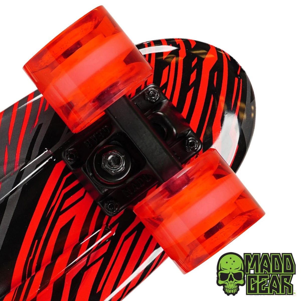 Close-up of the Madd Gear MGP G-Retro Racer Complete Cruiser, dimensions 22.5" x 6.25", displaying a retro short board design with red and black zebra stripes. It is equipped with bright red translucent wheels featuring ABEC 9 bearings, along with a green skull logo and "Madd Gear" text situated in the bottom right corner.