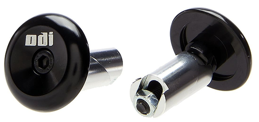 Close-up image of two ODI Aluminium Stunt Scooter Bar Ends in black. One is upright, showcasing the branded head with an Allen key bolt, while the other is tilted to reveal the durable fastening mechanism. Ideal for upgrading your handlebars with premium ODI scooter accessories.