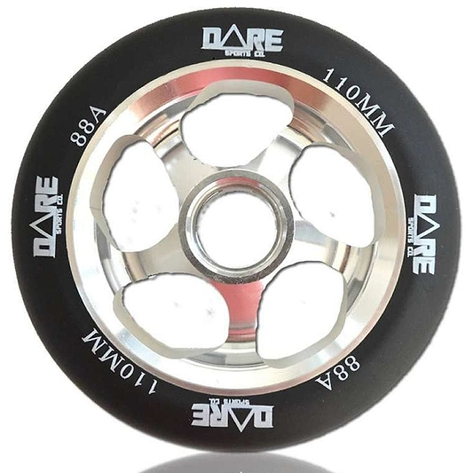 Close-up of the Dare Motion 110mm Stunt Scooter Wheel, showcasing a black tire with "DARE" branding. It features a silver metallic aluminum core with five large cutouts for a sleek and lightweight design. The polyurethane tire is specified as 110MM with an 88A hardness rating.