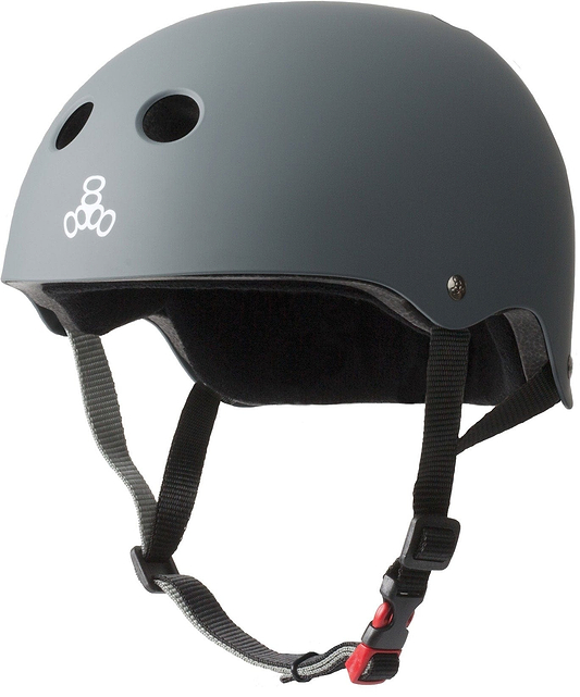 Introducing the Triple 8 Certified Sweatsaver Skate Helmet - Carbon by Triple 8. This helmet features a sleek gray matte finish with ventilation holes and adjustable black straps that include a distinctive red buckle. The side is adorned with a simple white logo, showcasing three interlocking circles. Designed to deliver dual-certified protection, it ensures superior high-impact absorption, making it perfect for both cycling and skating adventures.