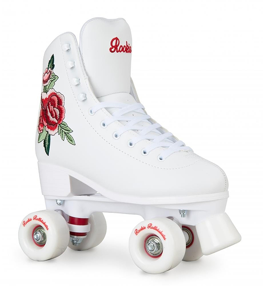 The Rookie Rosa Quad Roller Skates - White by Rookie offer vegan-friendly construction with beautifully embroidered red roses on the sides. They feature a white base plate and wheels, highlighted with red accents on the axles and branded details on the tongue.