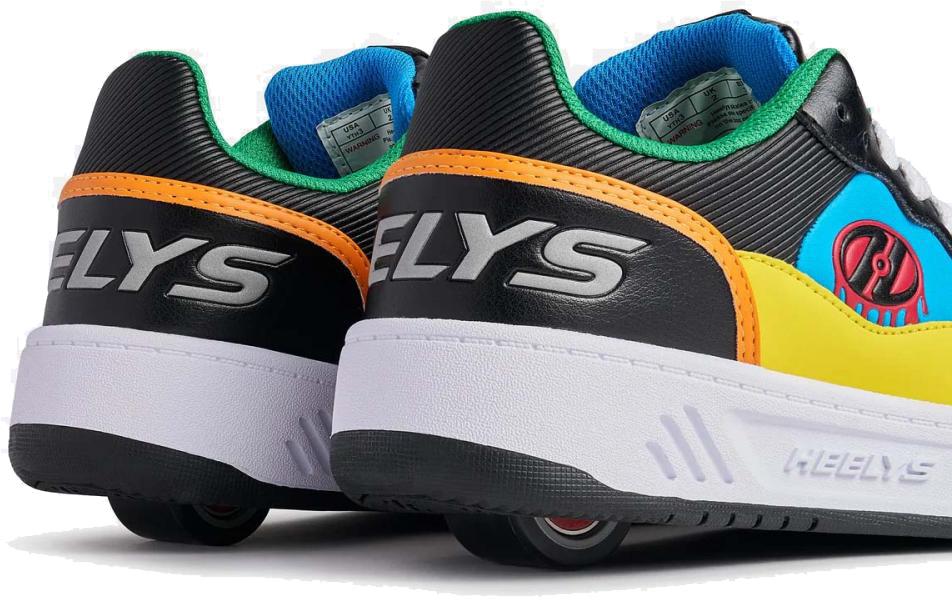 A close-up of two Heelys Rezerve Low Boys Shoes in black, red, cyan, and yellow—kids' roller shoes with visible wheels and "HELYS" branding on the back and sides.