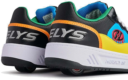 A close-up of two Heelys Rezerve Low Boys Shoes in black, red, cyan, and yellow—kids' roller shoes with visible wheels and "HELYS" branding on the back and sides.