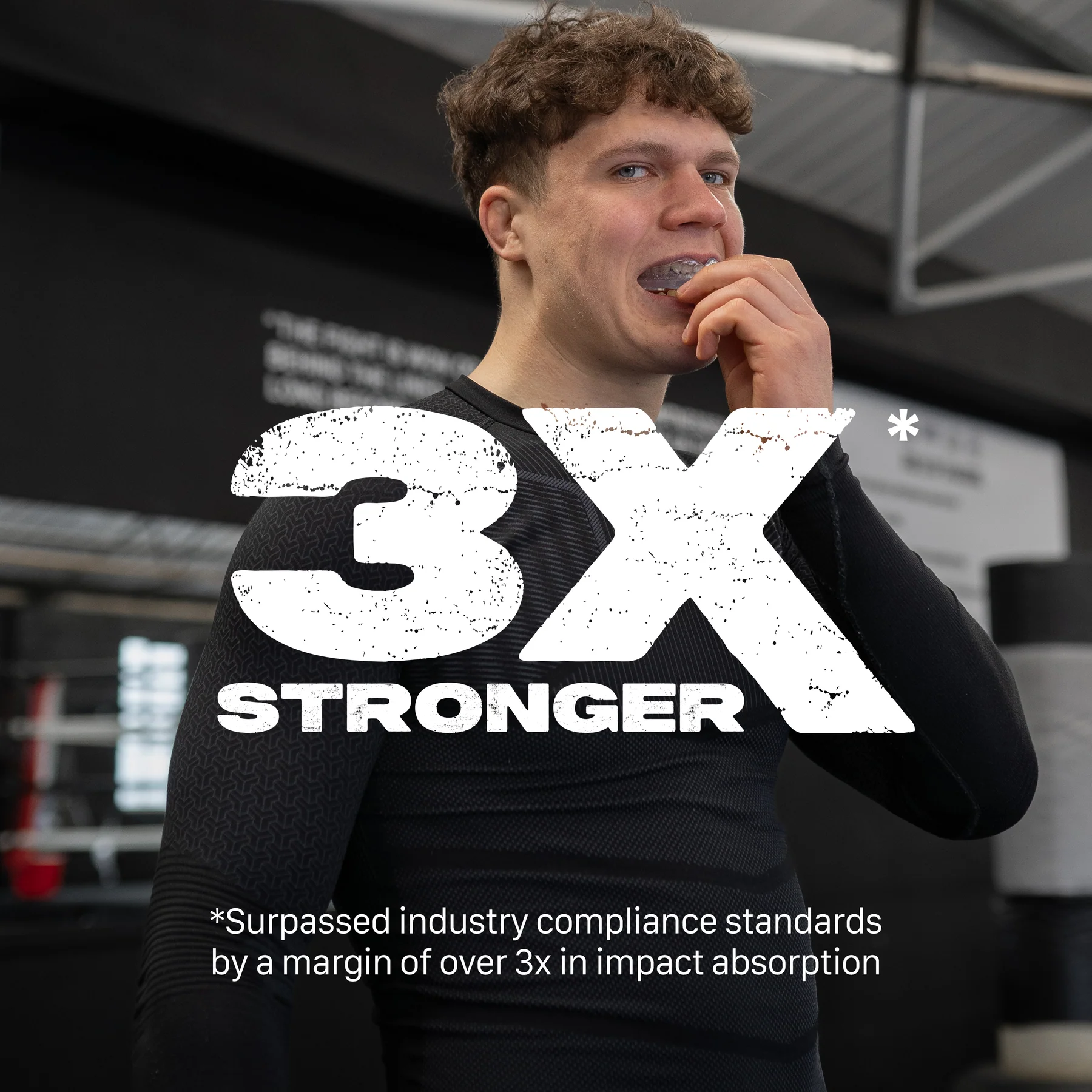 A young man in athletic wear bites into the Safejawz Intro Series Protection Mouthguard - Clear at the gym, showing its comfortable fit. Large text reads "3X STRONGER." Below: "Surpassed industry standards by 3x in impact absorption.