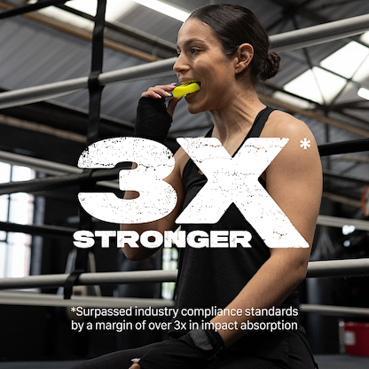 A woman in athletic wear sits in a boxing gym, fitting the Safejawz Intro Series Protection Mouthguard - Fluro Yellow. Large text reads “3X STRONGER,” with a note: “Surpassed industry compliance standards by over 3x in impact absorption.”.