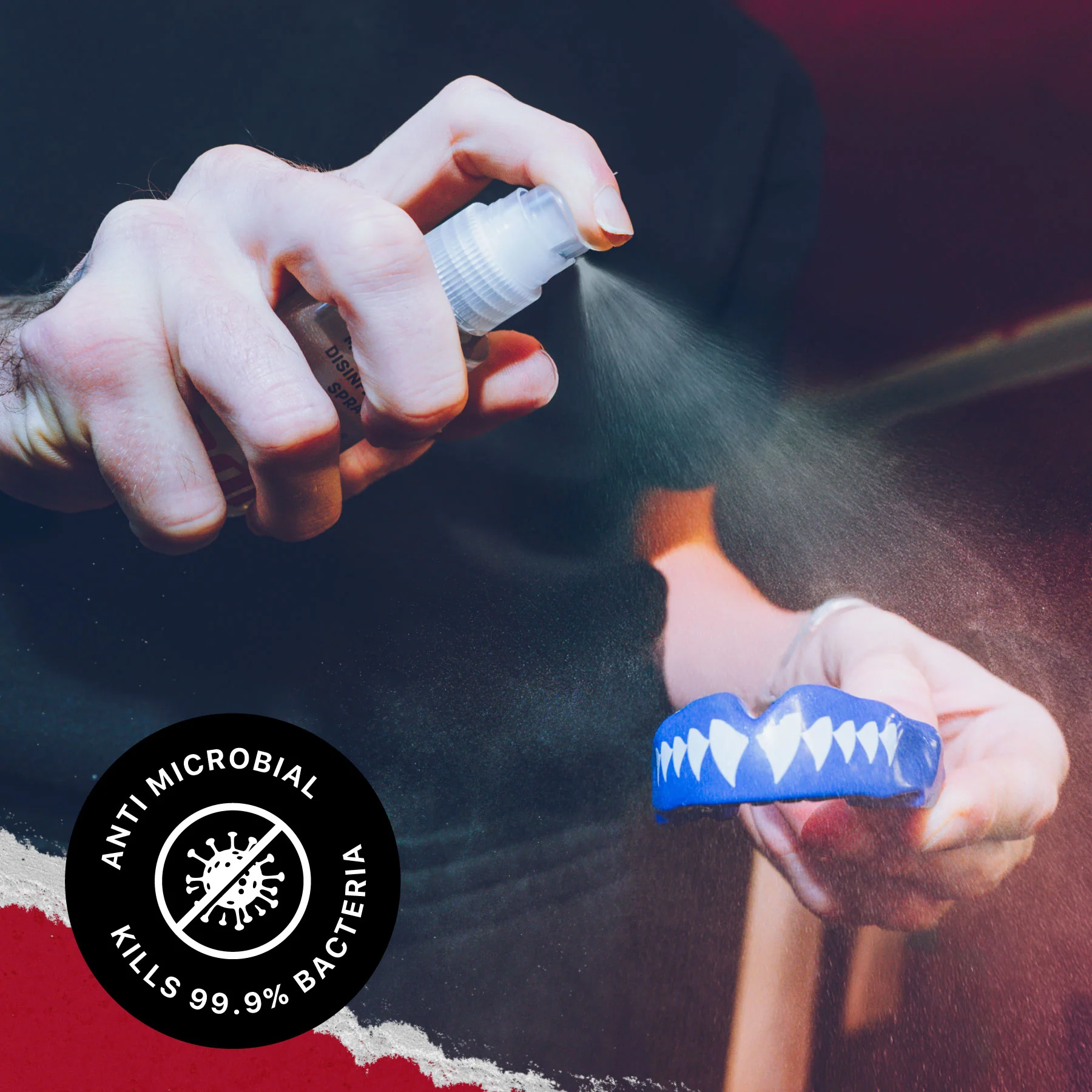 A hand sprays Safejawz Mouthguard Disinfectant 50ml Spray - Mint onto a blue mouthguard with white teeth design, showing the "Anti Microbial Kills 99.9% Bacteria" label and emphasizing sports hygiene and effective cleaning by Safejawz.