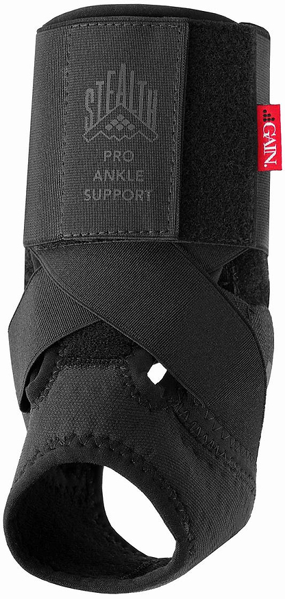 Black GAIN Stealth Pro Junior Ankle Support features crisscross straps, adjustable compression, and an open heel. A red "GENU" tag is on the side, offering optimal ankle protection under the GAIN brand.