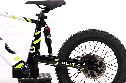 Close-up of the Duo 18" Blitz Kids Electric Balance Bike in White/Black, highlighting the thick rear tire, disc brake, suspension, and part of the frame against a white background.