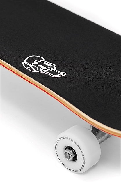 Close-up of the Enuff Lucky Cat Natural Complete Skateboard - 8.0" x 32" with black grip tape, a white cat graphic, white wheels, silver trucks, and visible wooden deck edge. Ideal beginner skateboard for street and park skating by Enuff.