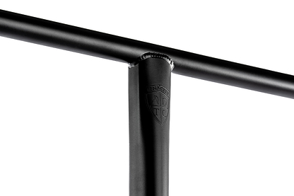 Close-up of a black Ethic DTC Tenacity V2 Oversized HIC Stunt Scooter T-Bar (770mm x 600mm) in durable 4130 chromoly steel, showing weld marks and an embossed ADTC shield logo on the upright bar, against a white background.