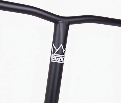 Close-up of Legacy Chromo Lite Steel Oversized HIC/SCS Stunt Scooter Bars in matte black (680mm x 610mm), featuring a white "Legacy" logo with stylized crown on the front. Made from durable chromoly steel; compatible with HIC/SCS setups. Plain white background.