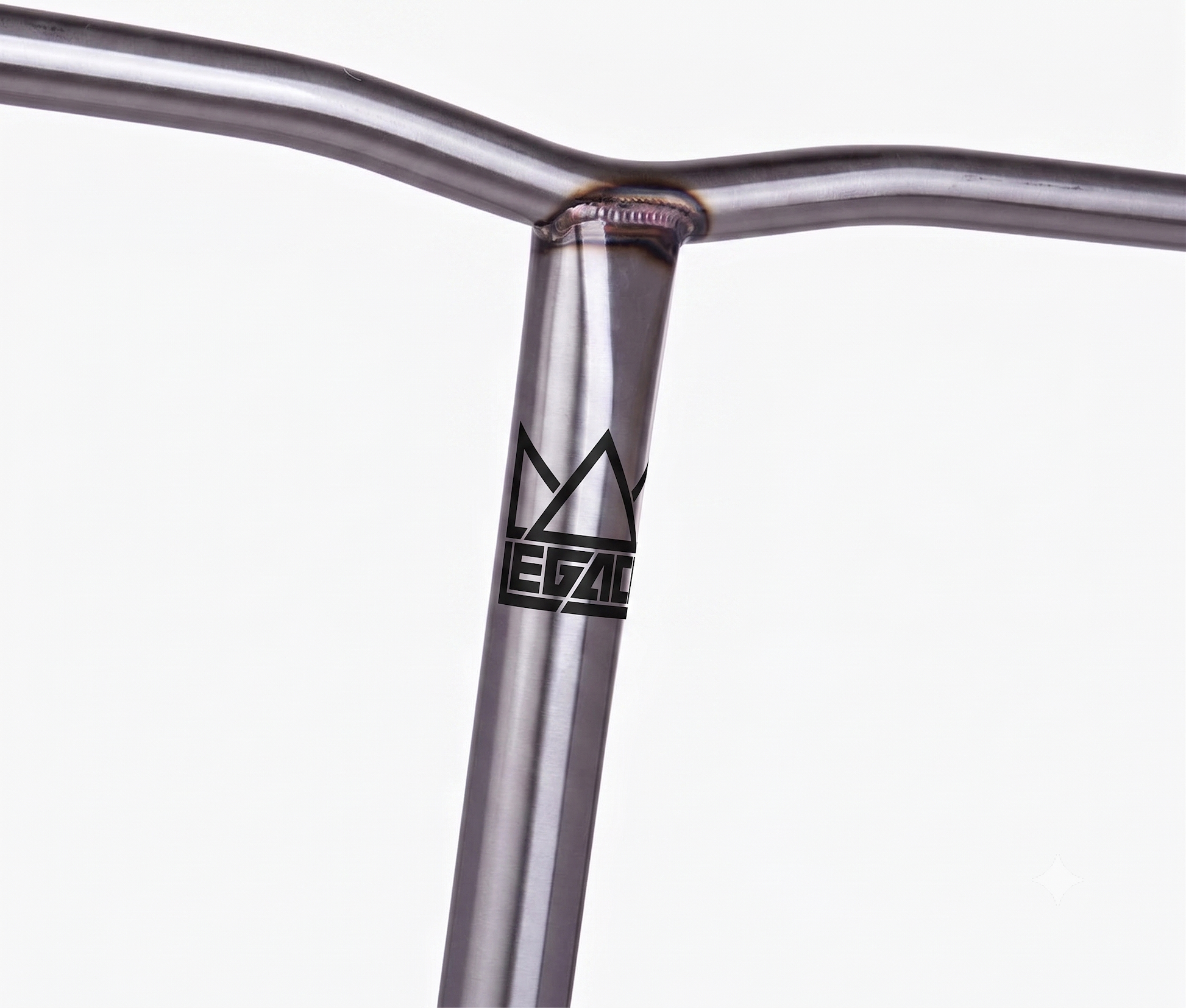 A close-up of the Legacy Chromo Lite Steel Oversized HIC/SCS Stunt Scooter Bars (Raw, 680mm x 610mm) shows a welded chromoly handlebar with a stylized crown and “LEGACY” logo on the vertical bar, set against a plain white background.