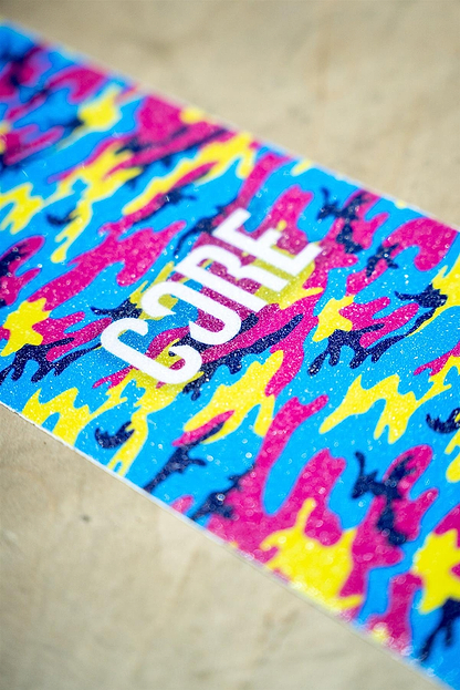 The CORE Stunt Scooter Griptape - Neon Camo by CORE features a vibrant blue, pink, and yellow camo design with "CURE" in bold white letters—making it a stylish upgrade for your stunt scooter.