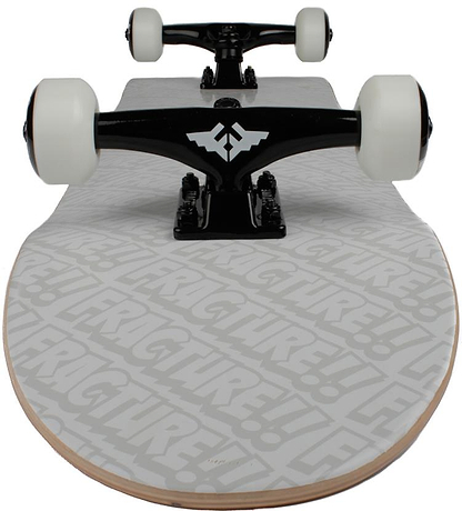 A close-up, front-facing view of the Fracture All Over Comic White Complete Skateboard (8.25" x 31.75") by Fracture, featuring white wheels, black trucks, and a light gray deck with bold “FRACTURE!!” branding.