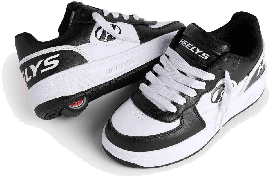 A pair of Heelys Rezerve Low Boys Shoes in black and white, beginner-friendly with white laces and the Heelys logo. One shoe is tilted to display the retractable heel wheel with smooth ABEC 5 bearings. Brand: Heelys.