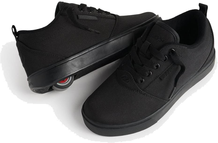 A pair of Heelys Pro 20 Boys Shoes - Triple Black Canvas, with one shoe on its side displaying a retractable wheel in the heel, showing they are kids' roller shoes by Heelys.