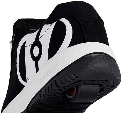 Close-up of the heel on Heelys Kolect Boys Shoes in black and white, featuring a retractable wheel with ABEC 5 bearings in the sole and circular tread. Bold graphic design highlights this signature style by Heelys, ideal for skating.