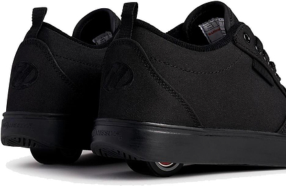 A close-up of Heelys Pro 20 Boys Shoes in Triple Black Canvas by Heelys, showing the retractable heel wheels for walking or rolling, displayed from back and side on a white background.