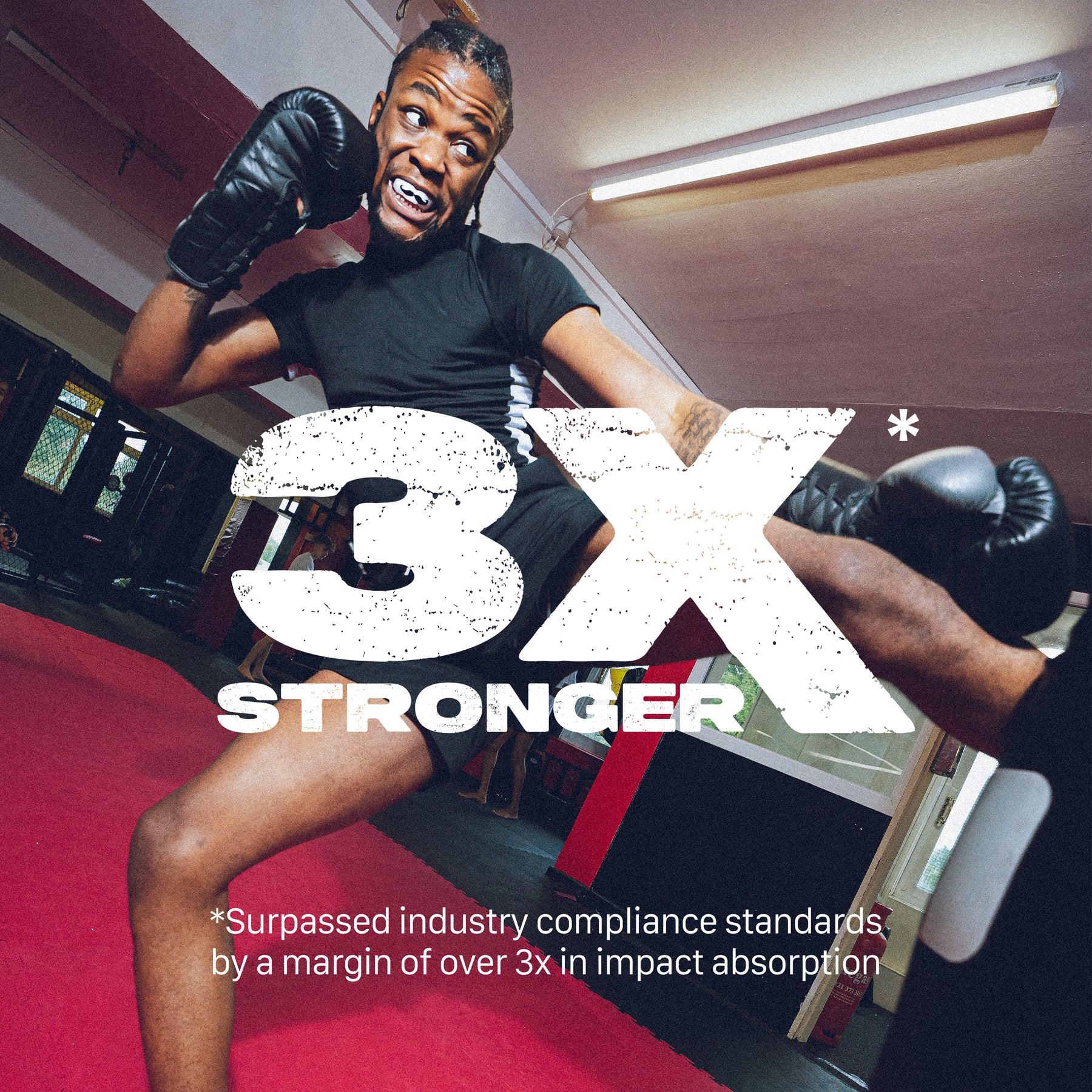 A young man in boxing gloves and athletic gear performs a high kick in a gym, with bold "3X STRONGER" text. The Safejawz Extro Series Protection Mouthguard - Mo by Safejawz delivers hi-impact protection, exceeding industry standards by over three times.