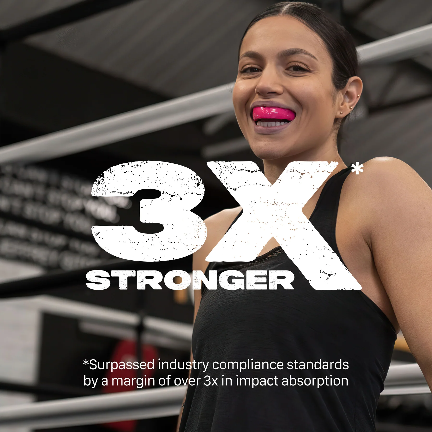 A woman in athletic wear smiles in a gym with boxing rings, wearing the Safejawz Intro Series Protection Mouthguard - Pink for jaw stability. Bold text reads "3X STRONGER" with a note on impact absorption. Brand: Safejawz.