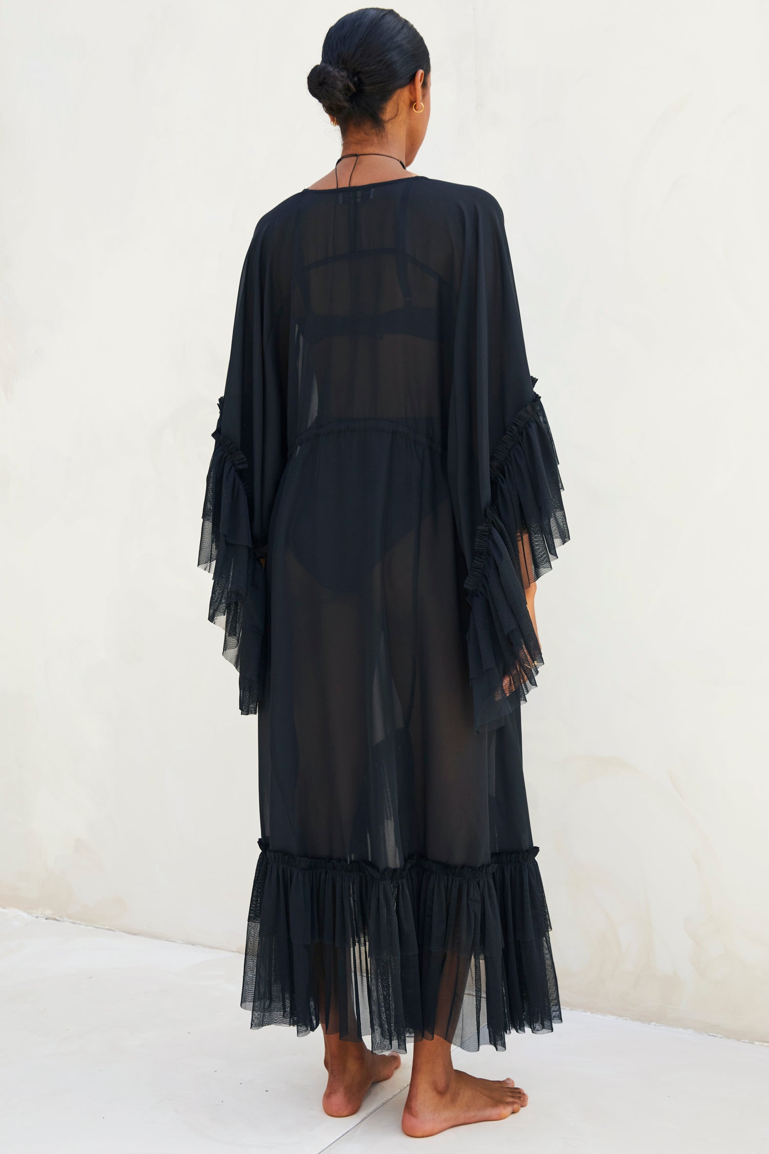 Model wearing Black Sloane Dress standing facing away from the camera 